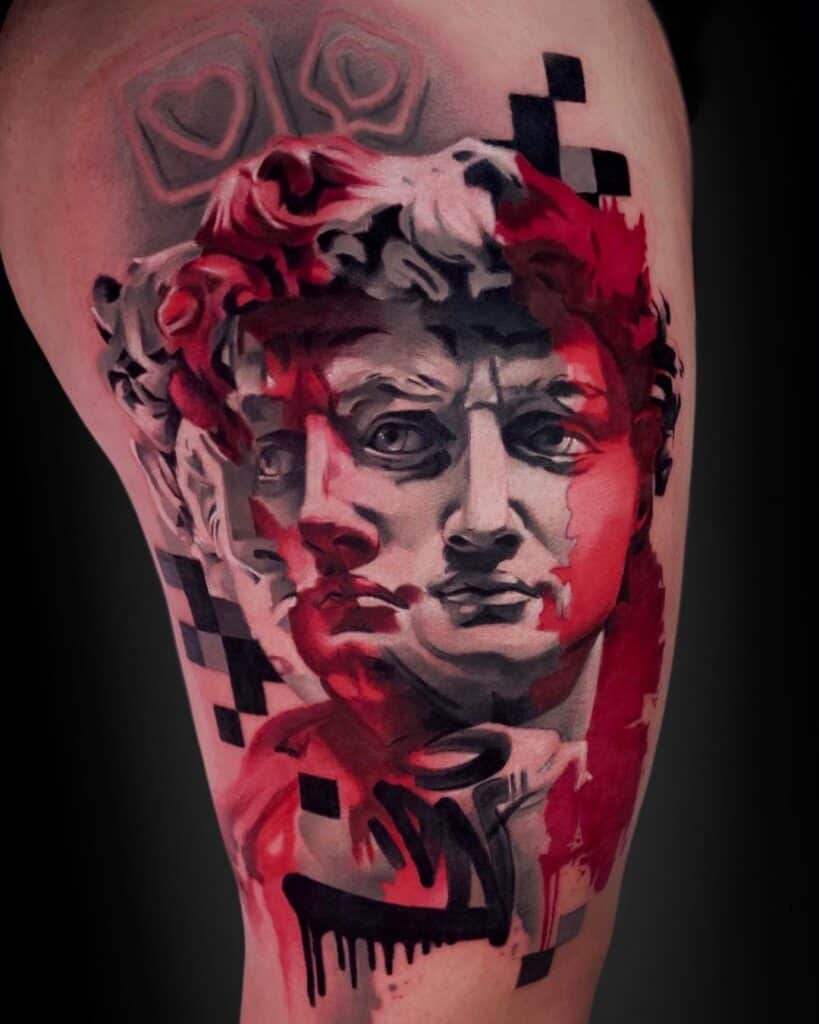 Surrealistic tattoo of a statue in black and gray with three heads, red color accents, graffiti and pixels on the leg