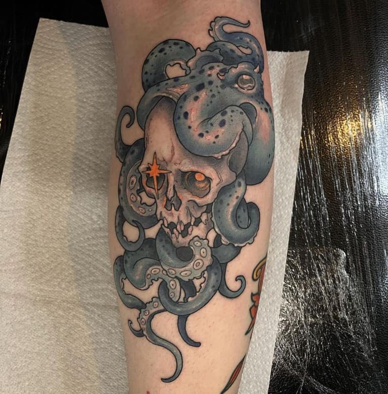 A neo-traditional skull with octopus tattoo in color on a lower leg