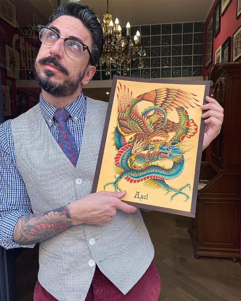 man with glasses holding an old-school artwork