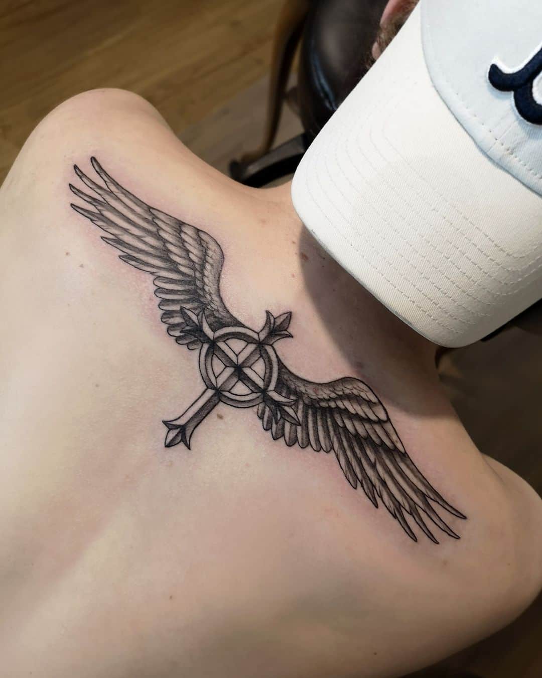 cross tattoo with wings on back